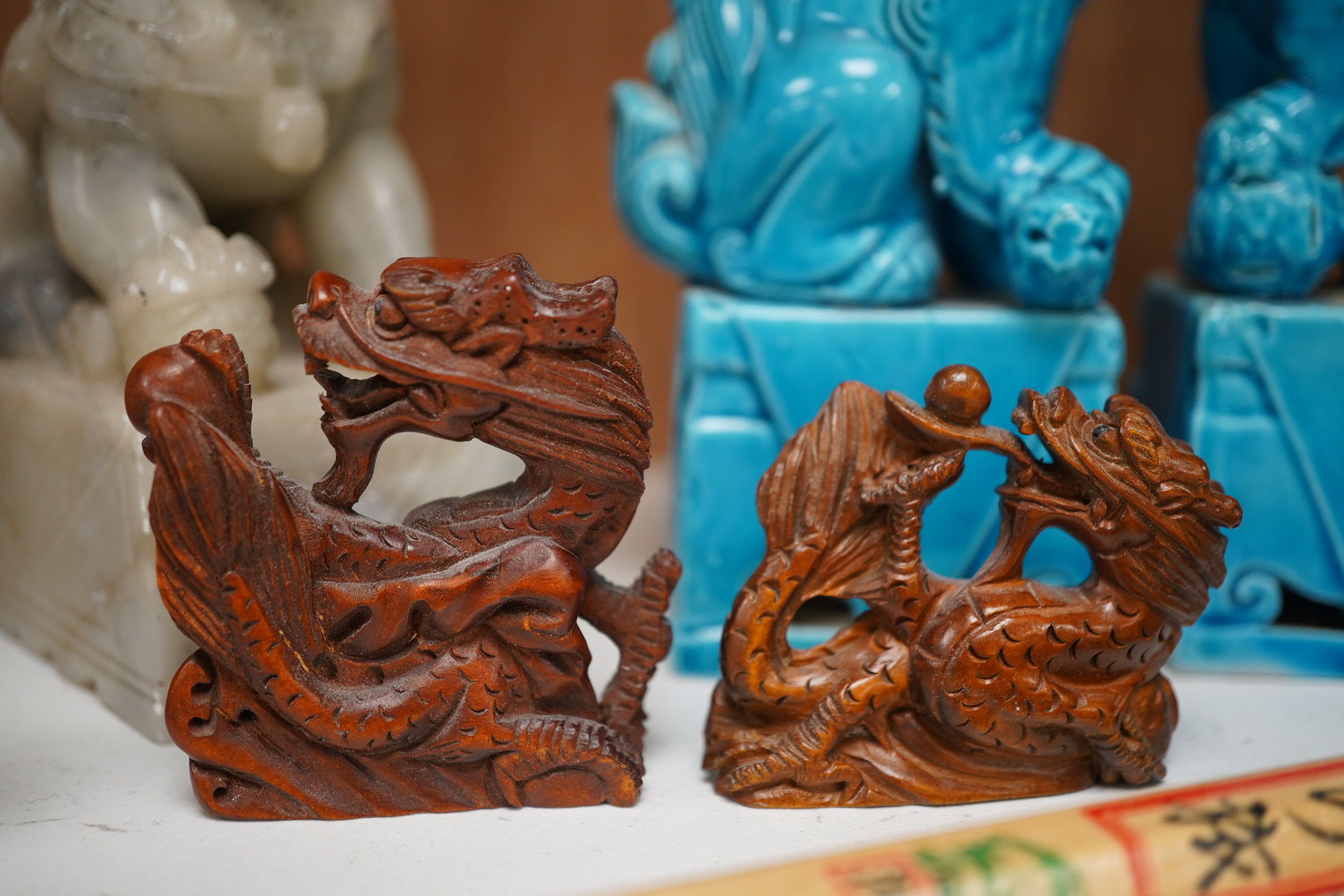 A group of Chinese items; a pair of turquoise glazed ceramic lion dogs, two pairs of soapstone carvings, various ‘dragon’ carvings etc. Condition - fair to good